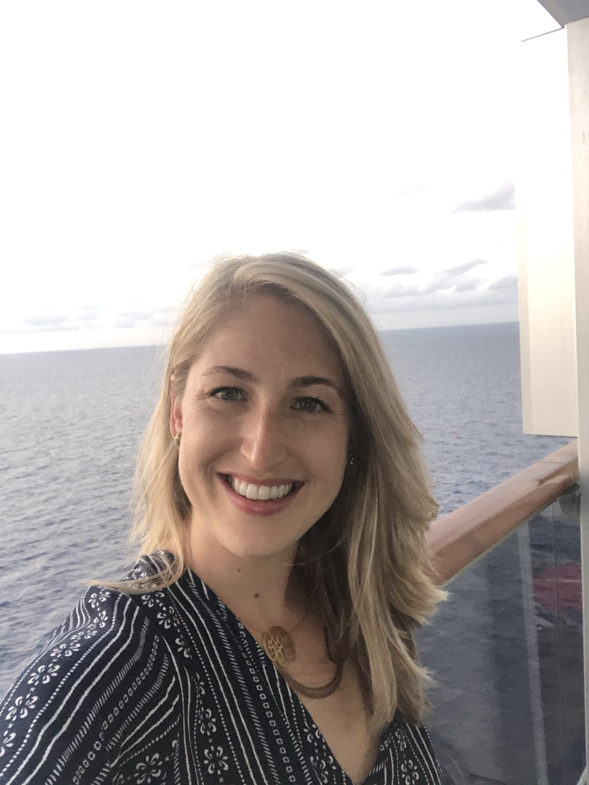 Caitlin enjoying an ocean view from a ship balcony